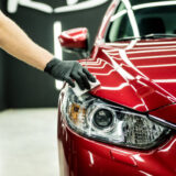 Car service worker applying nano coating on a car detail